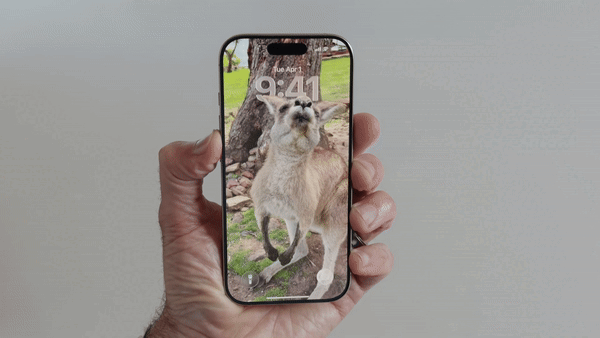 iOS 26 lock screen showing the Liquid Glass time display effect
